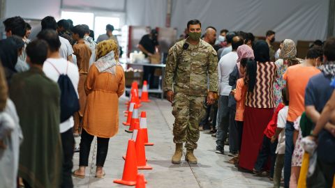 Afghan refugees line up for food in a dining hall at Fort Bliss' Doña Ana Village where they are being housed in Chaparral, N.M., Friday, Sept. 10, 2021. 