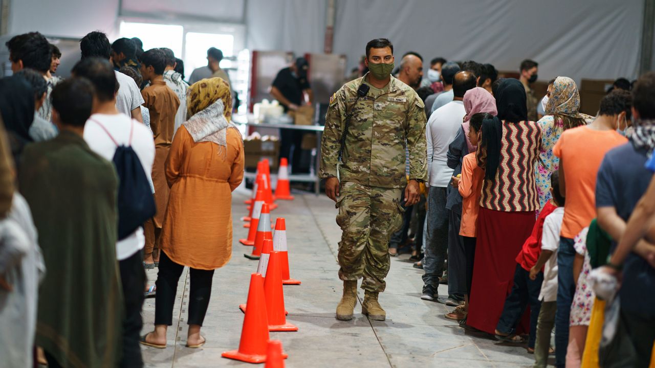 Afghan refugees line up for food in a dining hall at Fort Bliss' Doña Ana Village where they are being housed in Chaparral, N.M., Friday, Sept. 10, 2021.