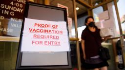 A sign stating proof of a Covid-19 vaccination is required is displayed outside of Langer's Deli in Los Angeles, California on August 7.