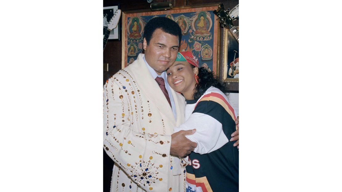 Muhammad Ali with his daughter Maryum "May May" Ali in 1988, wearing the boxing robe gifted by Elvis Presely that he would donate to New York's Hard Rock Café.