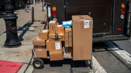 NEW YORK, NY - AUGUST 25: A cart of packages waits to be delivered by a United Parcel Service employee August 25, 2021 in New York City. During the summer of coronavirus, UPS drivers are working over 12-hour shifts delivering a record number of packages while wearing masks. (Photo by Robert Nickelsberg/Getty Images)