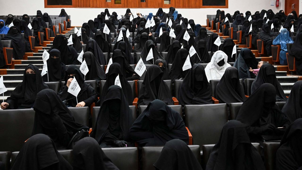 Veiled students hold Taliban flags as they listen a speaker before a pro-Taliban rally at the Shaheed Rabbani Education University in Kabul on September 11.