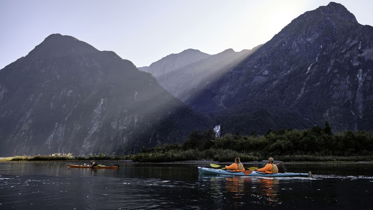 Tourists enjoing kayaking in the waters of the gorgeous Milford Sound. Before the pandemic, New Zealand came out the "Tiaki Promise."