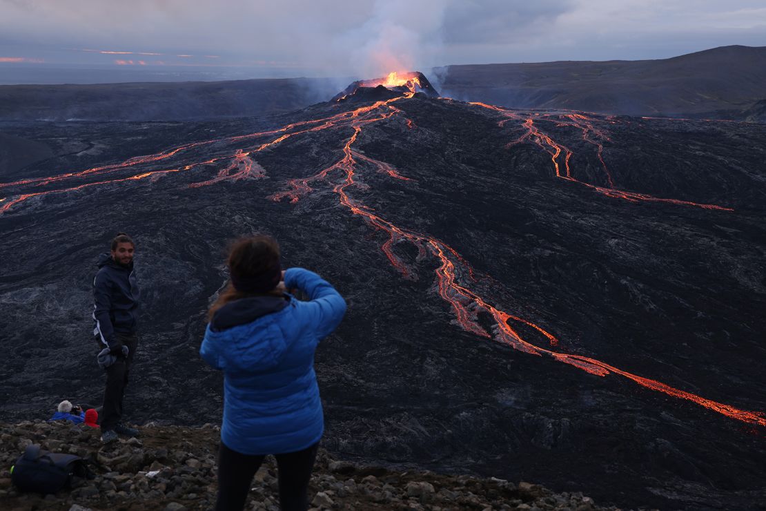 Visitors watch as Fargradalsfjall volcano spews molten lava on August 19, 2021, near Grindavik. Iceland is trying to help tourists make safety a top priority while out in its unpredictable landscape.