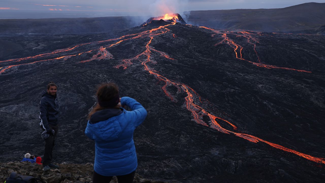 Visitors watch as Fargradalsfjall volcano spews molten lava on August 19, 2021, near Grindavik. Iceland is trying to help tourists make safety a top priority while out in its unpredictable landscape.