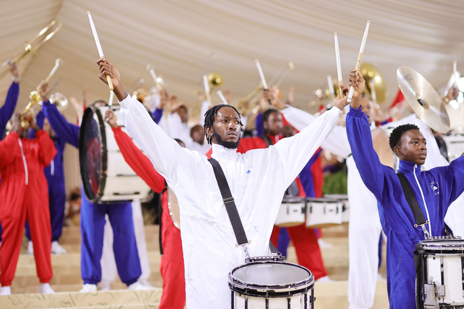 The Met Gala cream carpet began with a performance by the Brooklyn United Marching Band wearing red, white and blue.