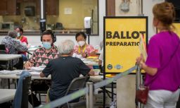 An observer watches election workers process ballots at the Orange County Registrar of Voters in Santa Ana, California, on Thursday, Sept. 9, 2021.