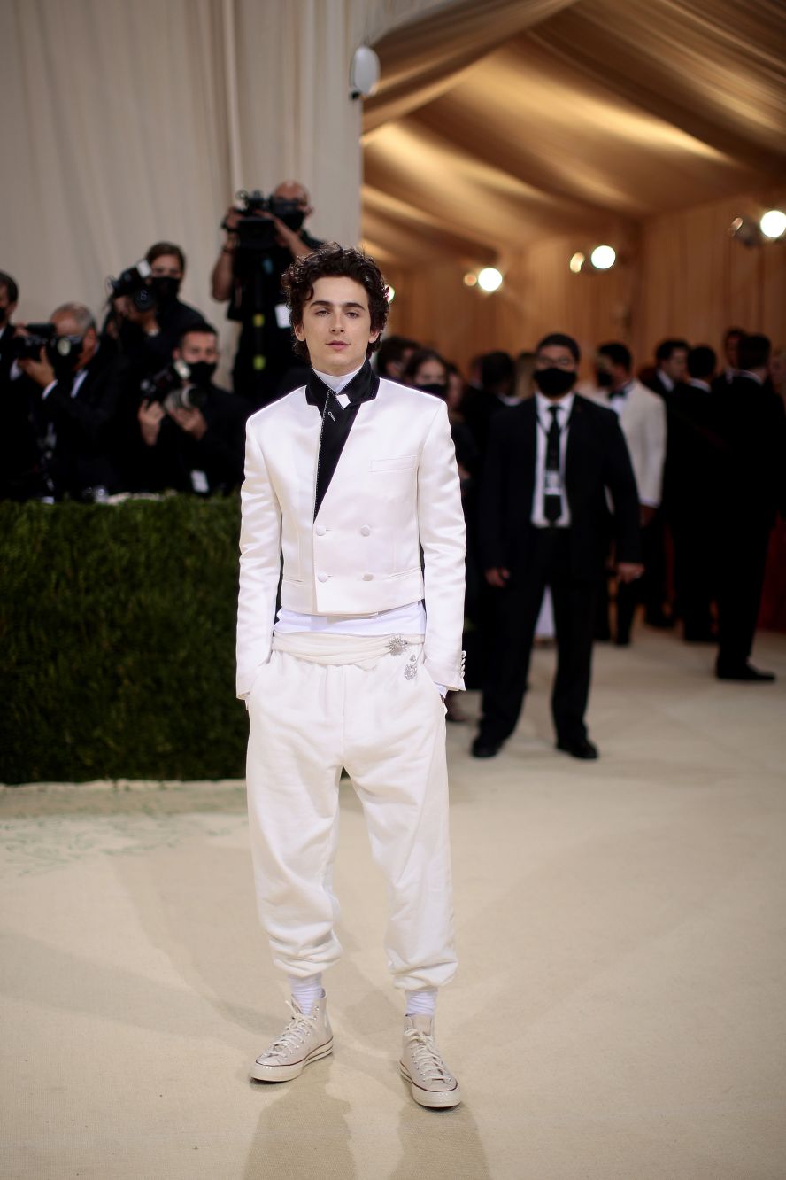 "Dune" star Timothée Chalamet mixed streetwear and black-tie with a shrunken white-satin suit jacket and billowing white pants, by Haider Ackerman, tucked into a pair of white Converse sneakers. Underneath, he wore a layer of Rick Owens.