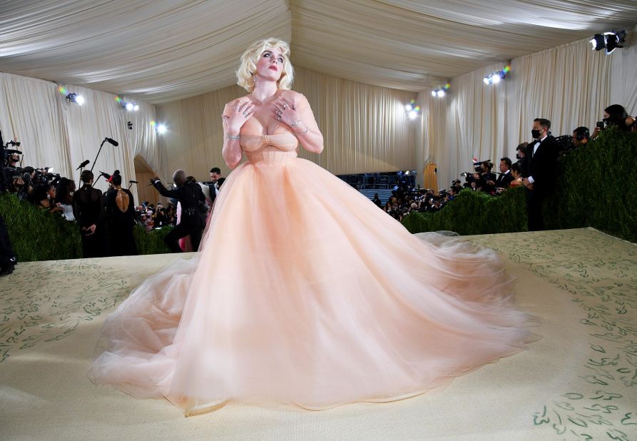 Met Gala co-chair Billie Eilish arrived in a voluminous peach Oscar de la Renta gown and the bleach-blonde hair she's been wearing since she released her sophomore album "Happier Than Ever."