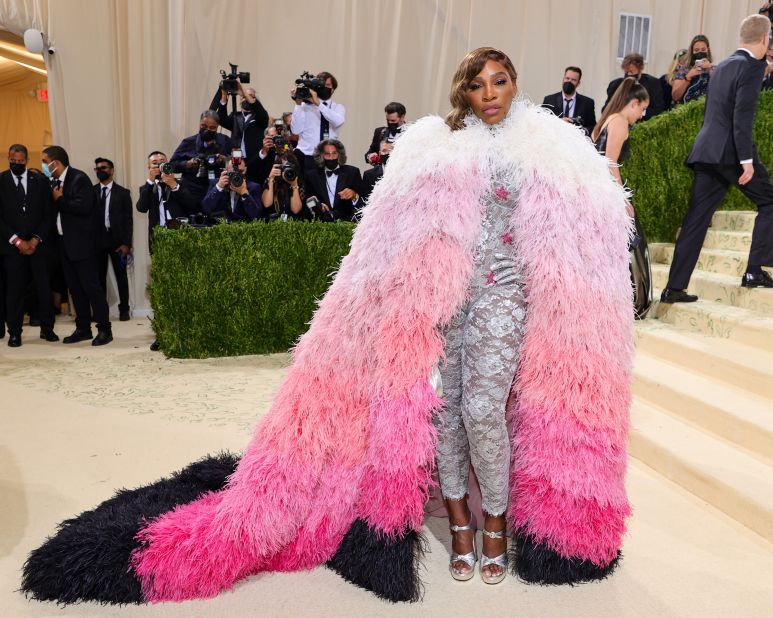 Serena Williams told E! that her outfit was "superhero" inspired. She wore a lace silver bodysuit with gloves underneath an opulent pink and white ombré feather cape.