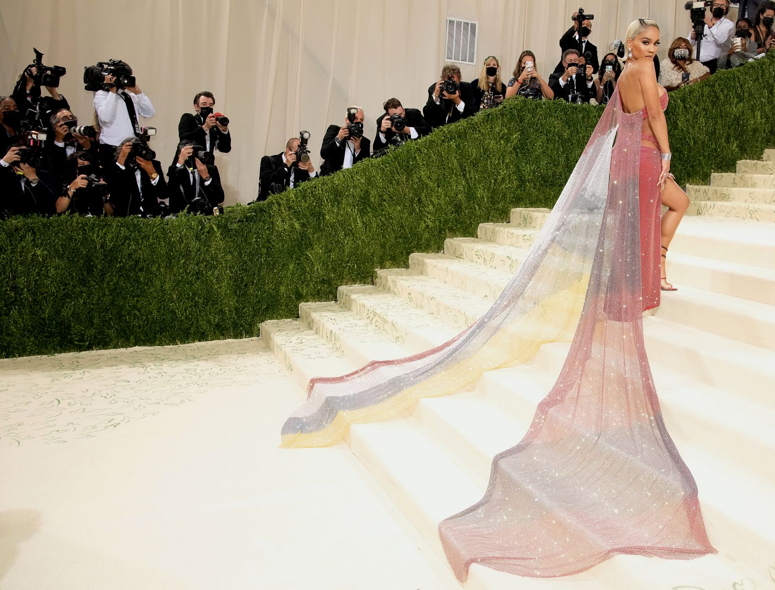 Saweetie's rainbow ombré Christian Cowan dress trailed behind her as she walked the Met's famous stairs. She revealed later told Vogue that the colors were inspired by her Filipino heritage, as well as the Black American heritage flag.
