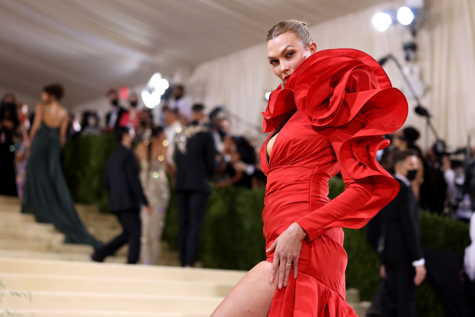 Karlie Kloss wore a bold red Carolina Herrera gown with striking structural details. She also carried a clutch detailed with a large floral rosette, in keeping with the design of her dress.