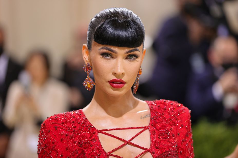 Actress Megan Fox sported pinup-style bangs in a daring red Dundas dress with a lace-up plunging v-neck and a high slit. According to the label's press release, the outfit was inspired by Art Deco aesthetics.