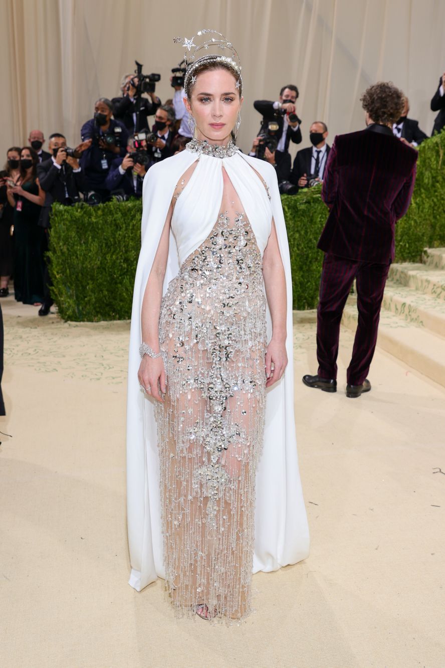 Emily Blunt shimmered in a cosmic, white dress by Miu Miu. Her star-adorned headband was a tribute to silver screen star Hedy Lemarr, who wore a gigantic version in the 1940s.<br />