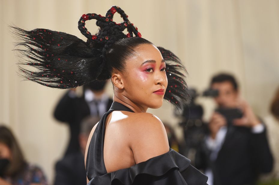 Naomi Osaka brought her Japanese and Haitian background together in an ensemble by Louis Vuitton. Her sister Mari Osaka, a fashion designer, worked with creative director Nicolas Ghesquirre to create the look which incorporated a Japanese obi belt and ruffles. On Instagram, Mari said the outfit referenced Haitian Quadrille dresses.