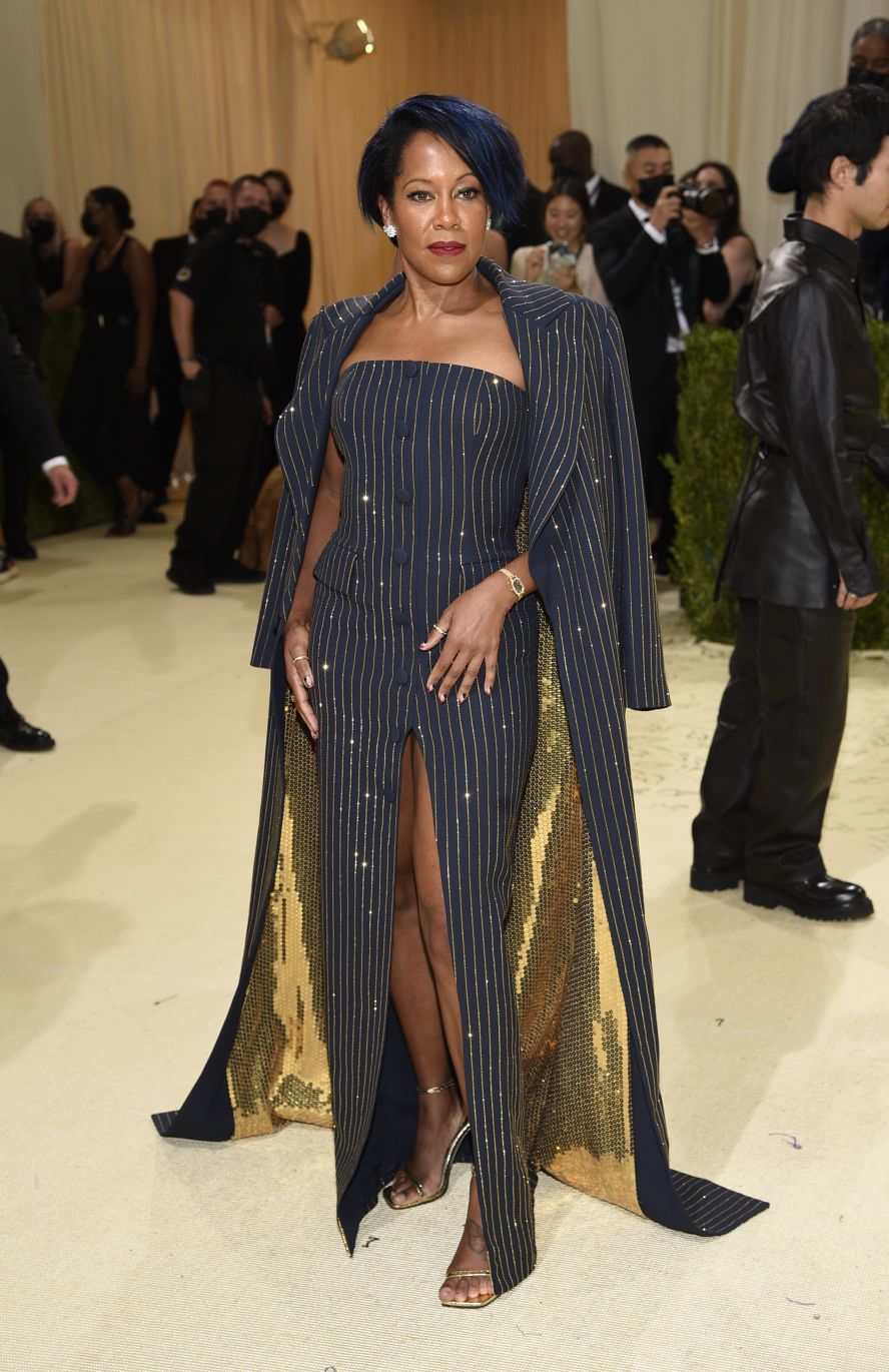 Regina King joined Michael Kors at the venue, where she was snapped wearing a sparkling pin-striped outfit. Featuring a gold sequined lining, navy overcoat and form-fitting gloves, she matched the look with a streak of color in her hair.