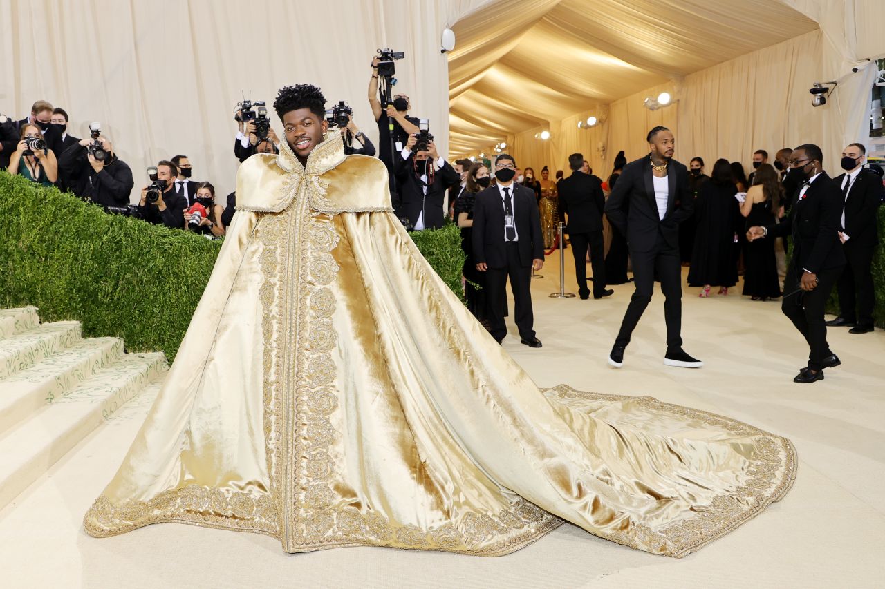 Lil Nas X brought spectacle to the red carpet with not one but three different looks by Versace. First, he wore this regal golden cloak with delicate embroidery around the hem and collar.<br />