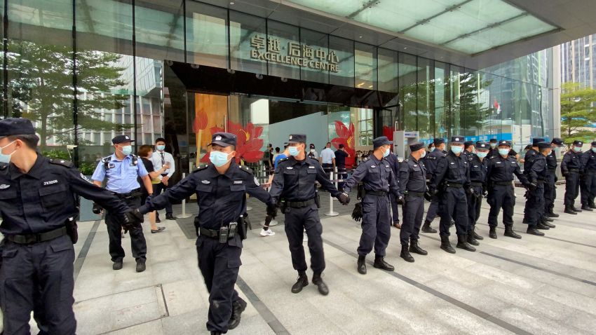 Security personnel form a human chain as they guard outside the Evergrande's headquarters, where people gathered to demand repayment of loans and financial products, in Shenzhen, Guangdong province, China September 13, 2021. REUTERS/David Kirton