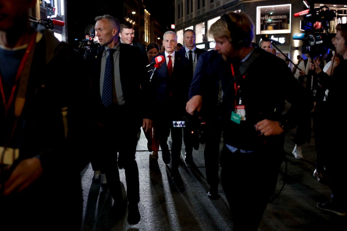 Labour leader Jonas Gahr Støre, center, surrounded by security guards and journalists in teh early hours of Tuesday.