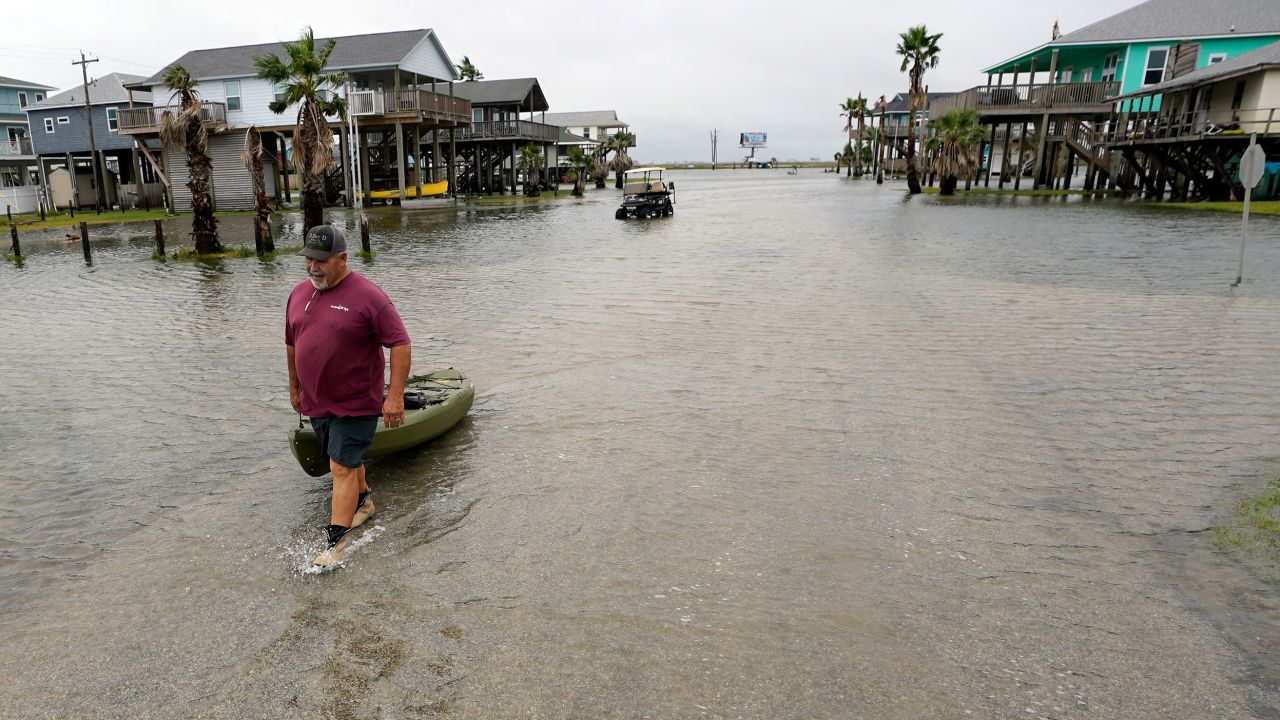 Bubba Ferguson drags a kayak through a flooded street in San Luis Pass, Texas.