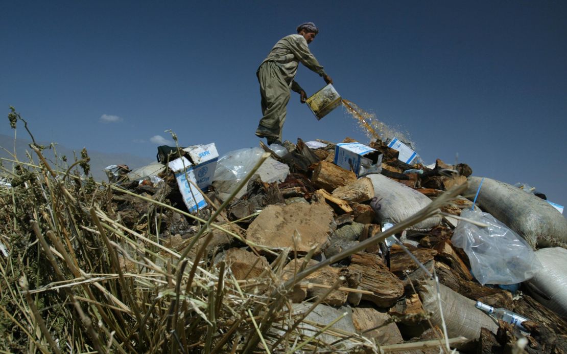 An Afghan worker pours gasoline on a large pile of illegal drugs that were destroyed in September 2004 in Kabul.