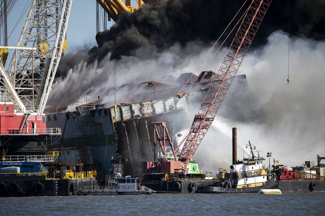 Firefighters spray water into the cut-away mid-section of the Golden Ray on May 14, 2021.