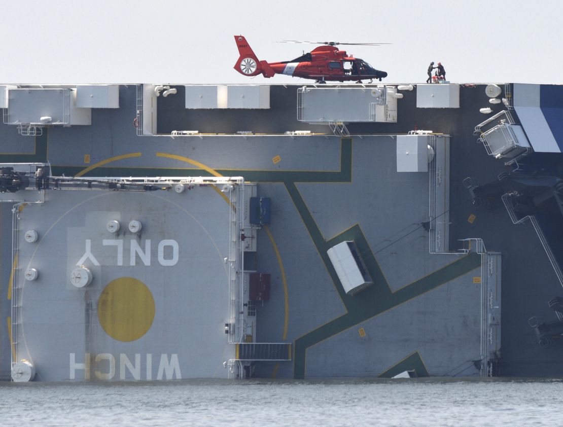 Members of the US Coast Guard unload supplies from a Coast Guard helicopter from the side of the Golden Ray on September 9, 2019, the day after it capsized.