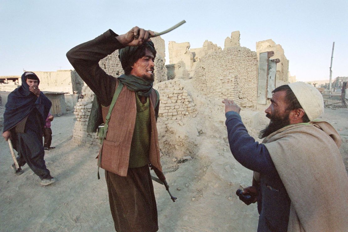 A Taliban militiaman arrests and beats a man who was allegedly found in possession of half a kilogram of opium in Kabul in November 1996.
