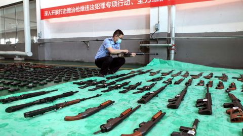 A police officer inspects confiscated illegal guns slated for destruction at an incineration facility in Shenyang, China, on June 17, 2020.