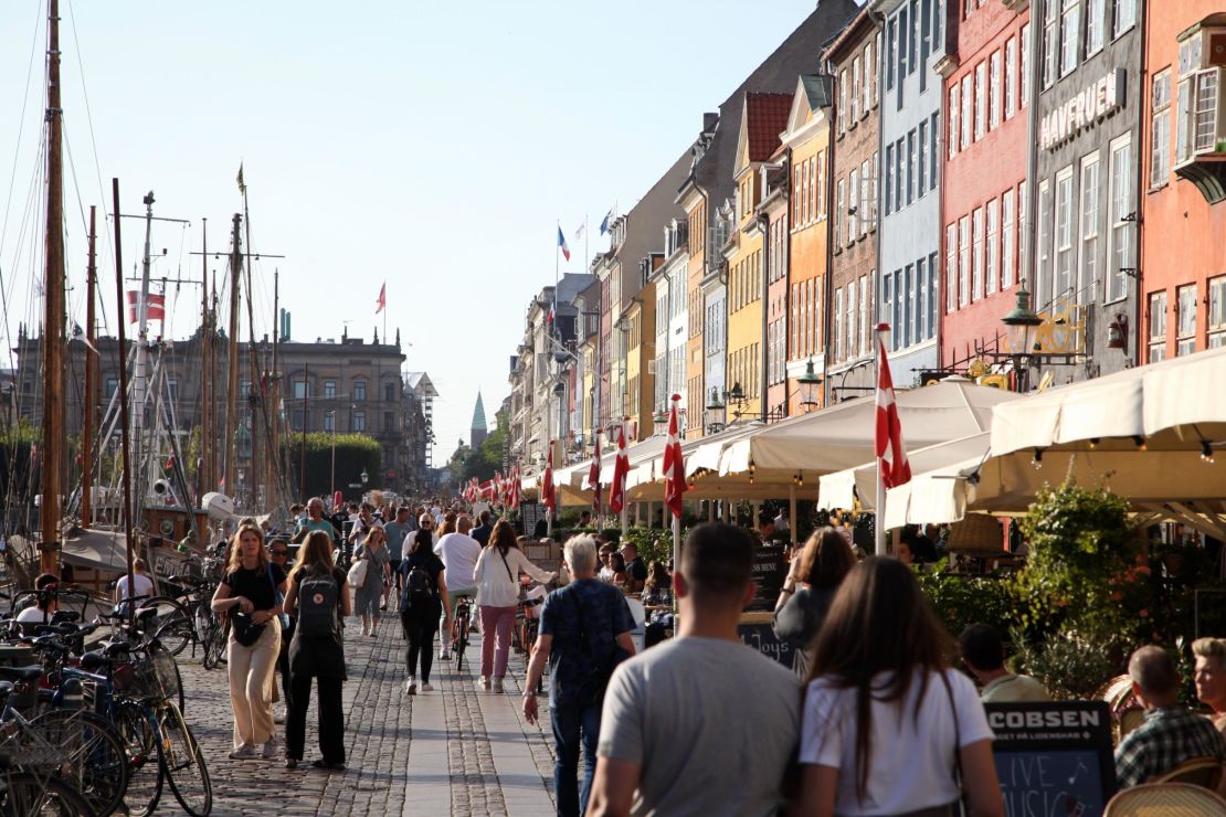 People walk along Nyhavn, a colorful harbor popular with visitors, in Denmark's capital, Copenhagen, on September 3.