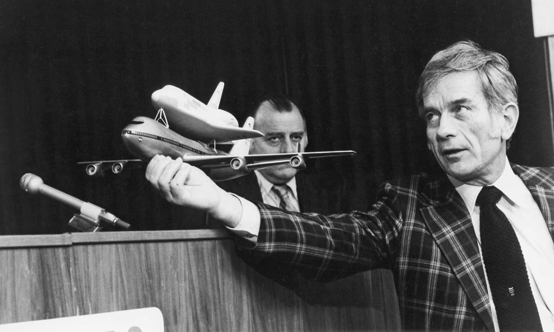 Former astronaut Deke Slayton, manager of the shuttle's Orbital Flight Test (OFT) program describes three upcoming "captive-active" phase flights at news conference in April 1977, as Johnson Space Center Public Affairs Officer Milt Reim looks on in the background. 