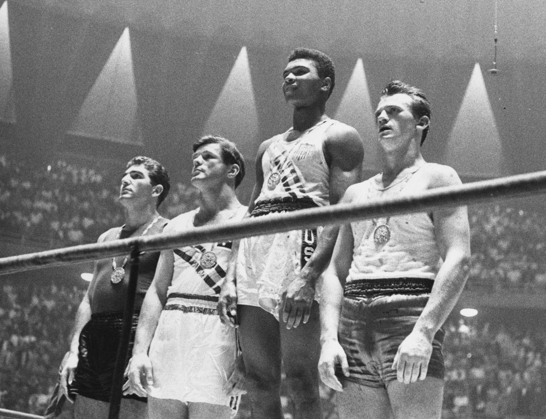 The winners of the 1960 Olympic medals for light heavyweight boxing on the podium at Rome: Cassius Clay, Zbigniew Pietrzykowski of Poland, Giulio Saraudi (Italy) and Anthony Madigan (Australia).