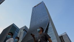 People walk in front of the Evergrande headquarters in Shenzhen, China's southern Guangdong province on September 15, 2021, as the Chinese property giant said it is facing "unprecedented difficulties" but denied rumors that it is about to go under. 