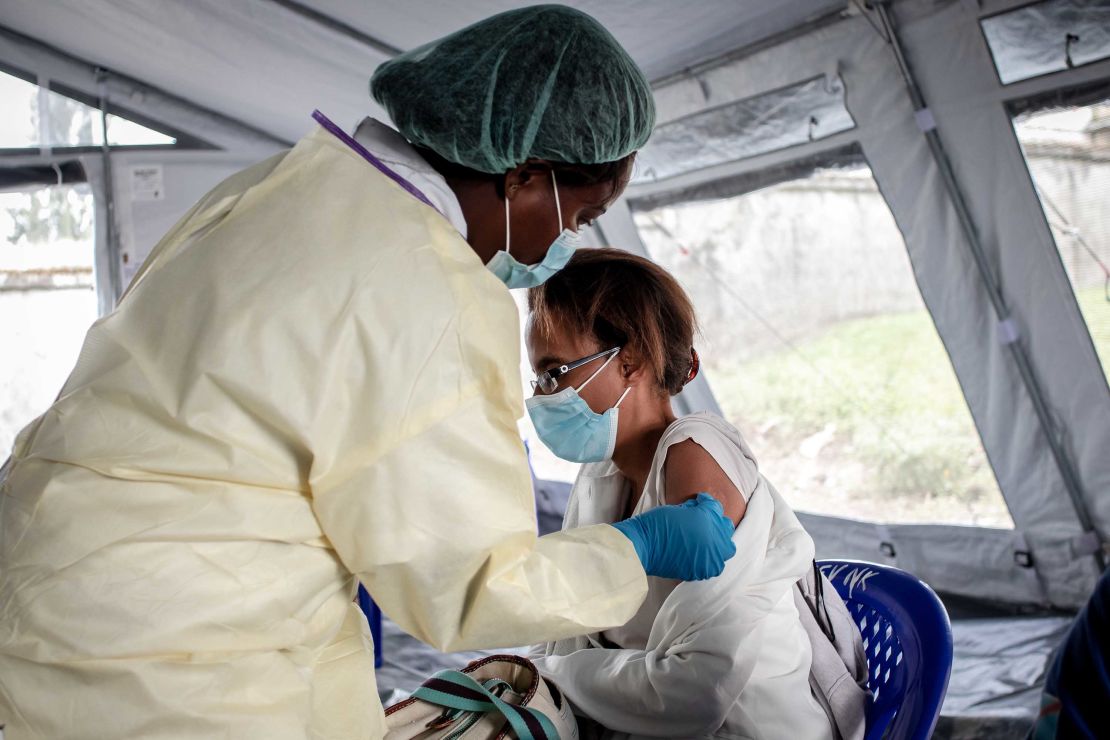 A health worker in the Democratic Republic of Congo vaccinates a woman with the AstraZeneca vaccine in May.