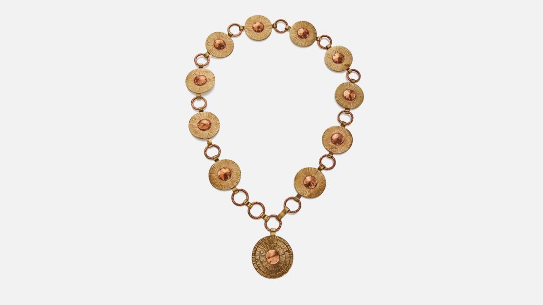 A necklace and belt design, by jeweler Winifred Mason Chenet, crafted from brass and copper. The piece is stamped with her signature "Chenet" and the word "Haiti."