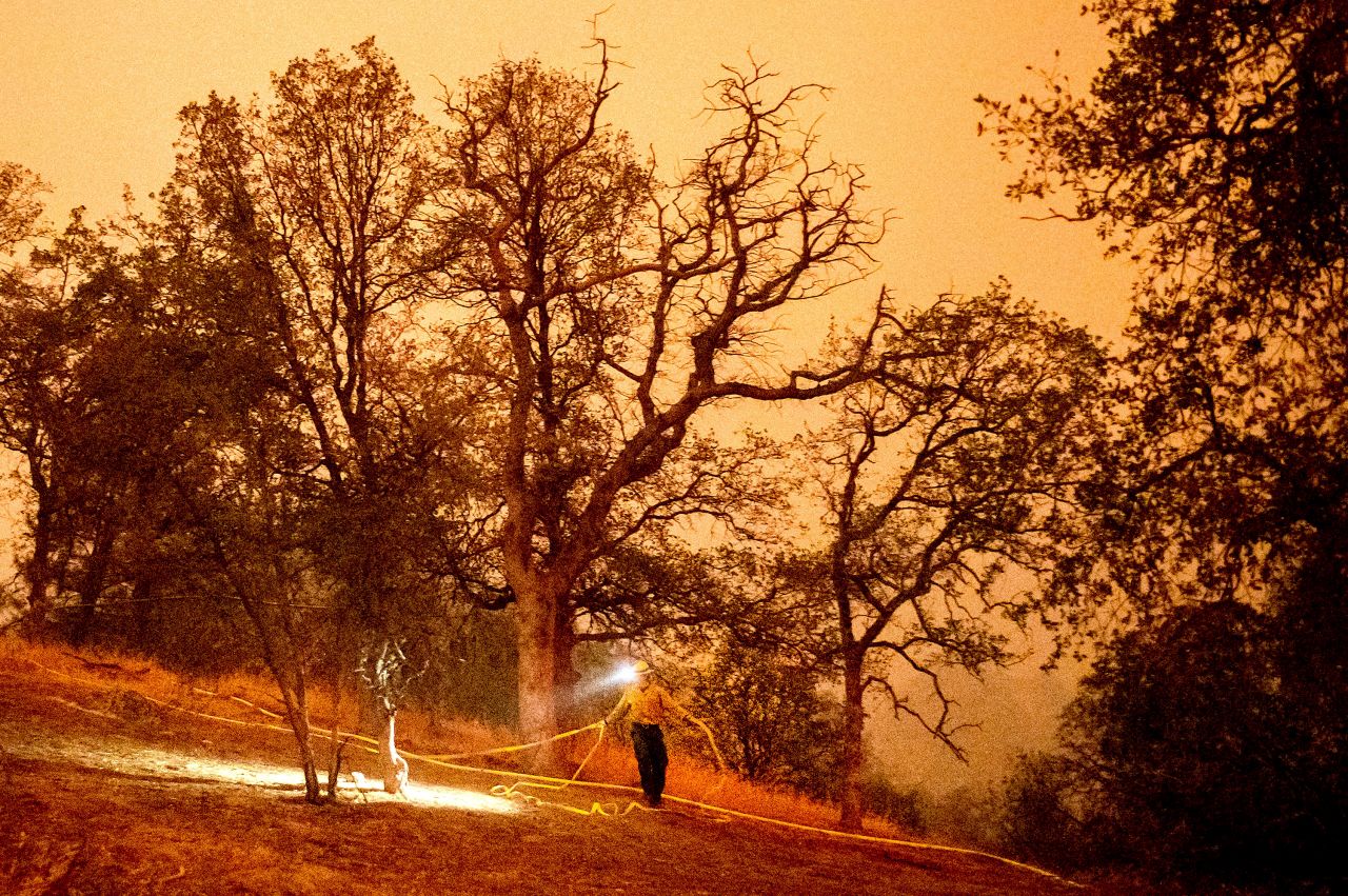 A firefighter lays hose around the Foothills Visitor Center while battling the KNP Complex Fire in California's Sequoia National Park on Tuesday, September 14. The park was closed because of <a href="https://www.cnn.com/travel/article/sequoia-national-park-closed-wildfire-threat/index.html" target="_blank">wildfires burning in the state's Sierra Nevada mountains.</a>