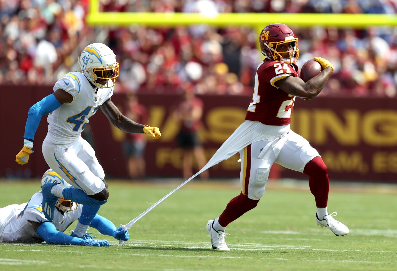 A couple of Los Angeles Chargers try to bring down Washington running back Antonio Gibson during an NFL game in Landover, Maryland, on Sunday, September 12. It was the opening weekend of the NFL's regular season.
