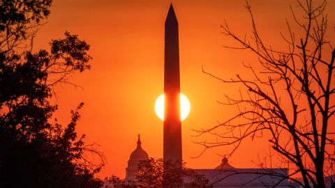 The sun rises behind the Washington Monument in the US capital. 