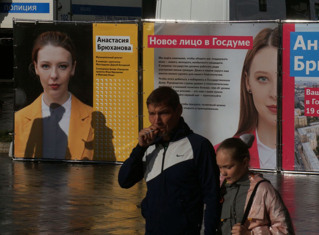 People walk past posters of Anastasia Bryukhanova, an independent candidate for the State Duma poll, on September 5.