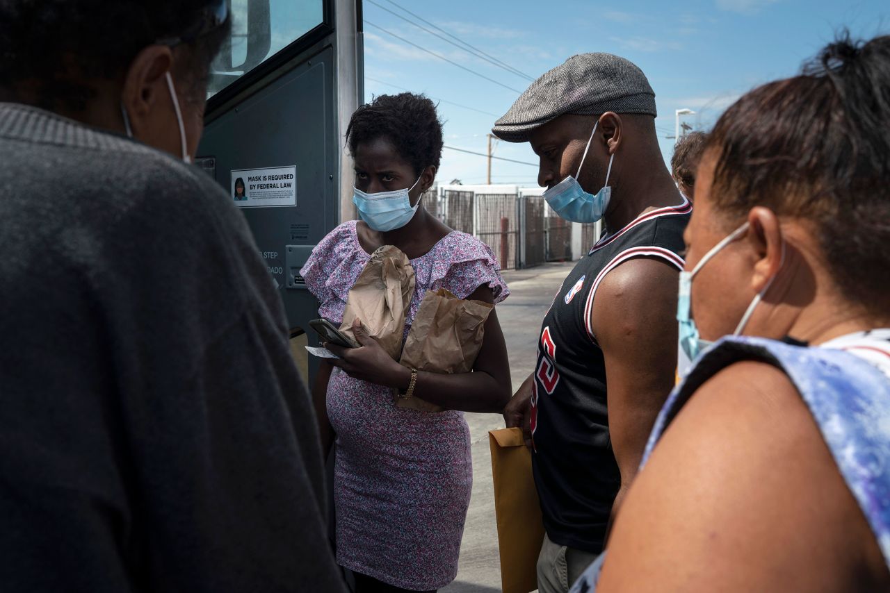 Cuban asylum seekers Otto Jesus, center, and his longtime partner, Yanet, left, board a bus after being processed by authorities in Del Rio on September 16.