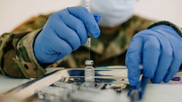 A member of the National Guard prepares a dose of the Pfizer-BioNTech Covid-19 vaccine at the University of New Orleans Lakefront Arena drive-thru facility in New Orleans, Louisiana, U.S., on Tuesday, Aug. 24, 2021. The Louisiana Department of Health reported an increase in confirmed Covid-19 cases by 8,296 on Monday. Photographer: Bryan Tarnowski/Bloomberg via Getty Images