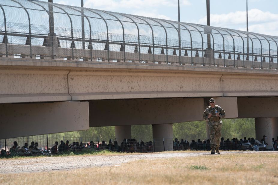 Asylum seekers wait to turn themselves in under the Del Rio International Bridge.