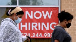 Women walk past by a "Now Hiring" sign outside a store on August 16, 2021 in Arlington, Virginia. (Photo by Olivier DOULIERY / AFP) (Photo by OLIVIER DOULIERY/AFP via Getty Images)