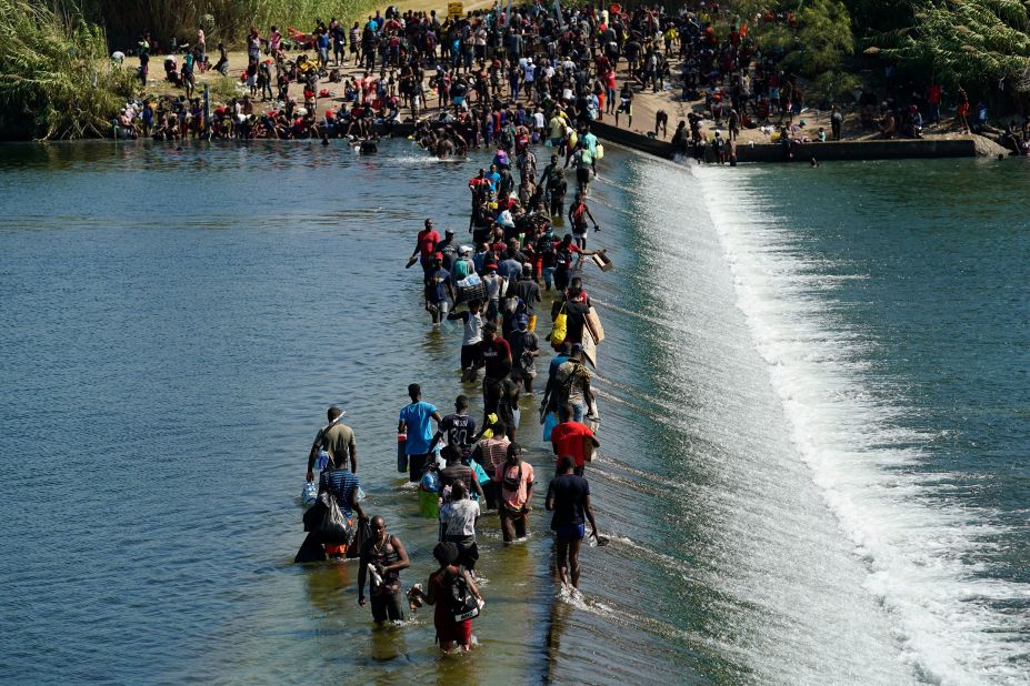 Migrants use a dam to cross to and from the United States from Mexico on Friday, September 17.