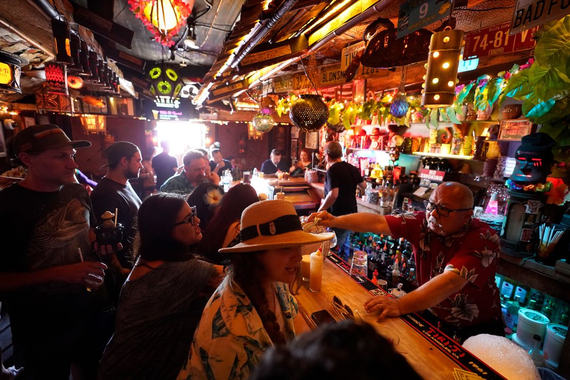 In this July 7, 2021, file photo, patrons enjoy cocktails in the tiny interior of the Tiki-Ti bar as it reopens on Sunset Boulevard in Los Angeles