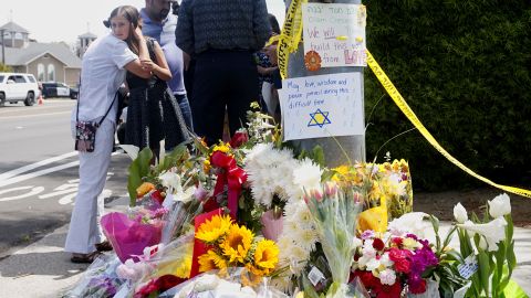 Mourners and well-wishers leave flowers and signs at a makeshift memorial across the street from the Chabad of Poway Synagogue on April 28, 2019, a day after the deadly shooting.