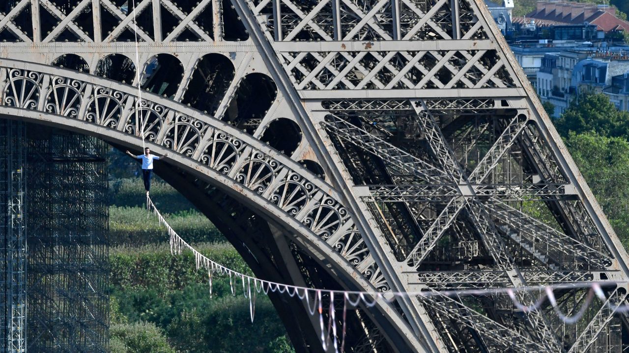 TOPSHOT - French highliner Nathan Paulin performs on a 70-metre-high slackline spanning 670 metres between the Eiffel Tower and the Theatre National de Chaillot, as part of the 38th European Heritage Days and the launch of the Cultural Olympiad in Paris, on September 18, 2021. - From the first floor of the Eiffel Tower to the Theatre National de Chaillot, the performance is the longest highline crossing in an urban environment. (Photo by Alain JOCARD / various sources / AFP) (Photo by ALAIN JOCARD/AFP via Getty Images)