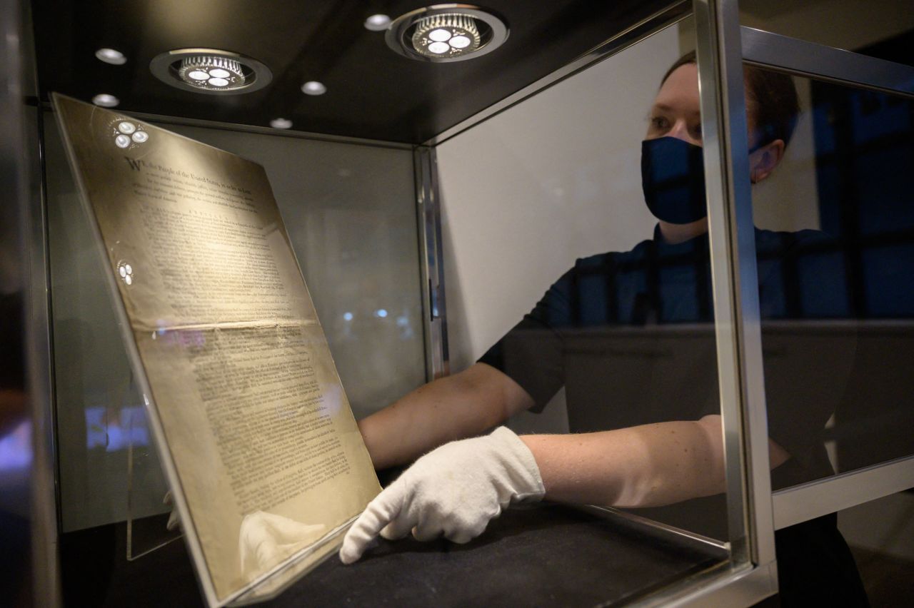 A Sotheby's expert presents a page of the first printing of the United States Constitution ahead of the sale.