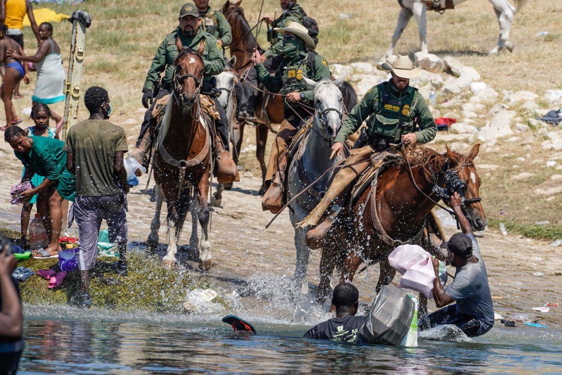 US Border Patrol agents on horseback try to stop Haitian migrants on Sunday from entering an encampment on the banks of the Rio Grande near the Acuna Del Rio International Bridge in Del Rio, Texas.