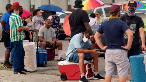 New Orleans residents, still reeling from flooding and damage caused by Hurricane Ida, wait for food and ice after they were struck by an oppressive heat wave in the days following the storm.